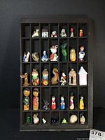 Full view of the wooden printer's tray filled with various small collectibles arranged in compartments