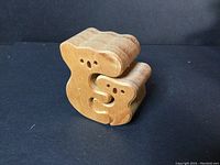 Side view of hugging koalas wooden puzzle made from light brown wood.