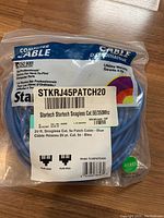 Photo of sealed 20 ft blue StarTech Cat5e snagless patch cable in original packaging showing label details.