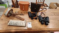 Overview of binoculars, stereoscope, and accessories on table.