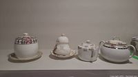 Four different sugar pots and corresponding saucers displayed on a white surface with neutral background.