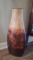 Front and side view of large ceramic floor vase showing tapered shape and multi-tone brown finish.