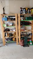 Full front view of two pine shelving units with various contents on shelves, contents not included in lot.