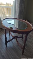 Full side view of vintage wooden side table with mirror inset on tabletop, showing overall design and slender turned legs.