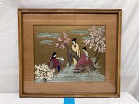 Framed oil painting showing the entire artwork with three Japanese women seated and standing near blossoming trees and water with clouds.