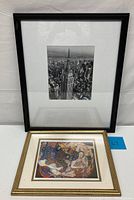 Two framed artworks: one black and white NYCscape photo featuring Empire State Building, and a smaller colorful psychedelic women artwork in a gold frame.