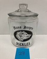 Front view of clear glass pickle jar showing Boars Head logo and Hans Jurgen Pickles branding.