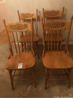 Four wooden press back chairs in light honey wood, shown from front and back, grouped together