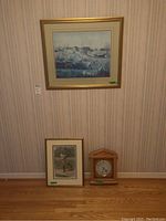Photo showing two framed prints and Bulova Quartz clock against wallpapered wall