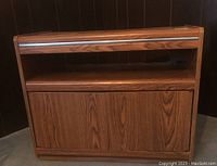 Front view of small veneer TV stand showing open top shelf and two doors below.