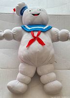 Front view of Stay Puft Marshmallow Man plush showing full body and details on limbs and sailor outfit.