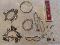 Top-down view of assortment showing multiple bracelets and loose charms including a bangle bracelet.