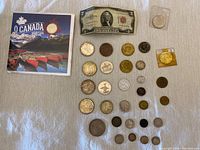 Canada 150 coin with various other coins and a US $2 bill