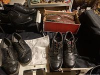Full view showing 3 golf carts and 4 pairs of used men's golf shoes in various styles and colors.