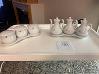 Overall view of condiment sets and bed tray on granite surface.