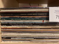 Stack of classical and assorted vinyl records showing titles like Chopin Piano Music, Vivaldi Four Seasons, Les Miserables, and more.
