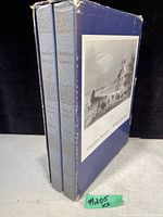 Two vintage hardcover books in blue slipcase with a black and white image of Canadian scenery on the front. Shows wear on slipcase edges.