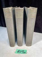 Three hardcover antique books with gray covers and gold lettering on spines, standing upright in a row.