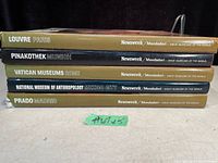 Spine view of the five coffee table books stacked, showing titles and publisher details.
