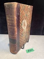 Front cover and spine of antique book with faded text on spine reading 'Harper's Magazine Vol. 62'. Marbled brown cover with leather-bound spine and signs of age wear.