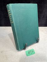 Front cover view of green hardcover book with gold lettering on spine and embossed front cover.