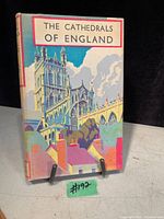 Front cover of the book showing title 'The Cathedrals of England' with a colorful illustrated cathedral scene on dust jacket and visible age wear.