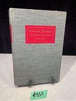 Front cover of the vintage book 'Charles Dickens His Tragedy and Triumph' Volume One showing gray cloth cover with red label.