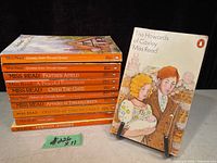 Lot of 11 Miss Read vintage paperbacks with one book displayed upright and others stacked