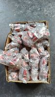 Box containing multiple individually bagged mini Coca-Cola can necklaces.
