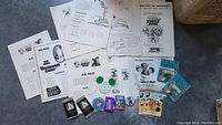 Overview photo showing Disney pressbooks, advertisement pads, colorful buttons and trading cards arranged on a flat surface.