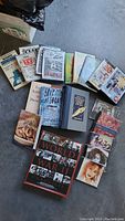 Media lot featuring books, DVDs, and CDs arranged on a surface, showing some titles and covers.