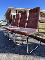 Four vintage 1970s dining chairs in a row outdoors showing button-tufted velvet seats and backrests with chrome cantilever frames.