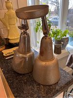 Pair of vintage retro metal pendant lights on counter with natural window light