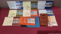 Wide angle photo showing multiple mint Canada stamp blocks mounted on thematic booklet pages with aircraft illustrations and a brown Hygrade booklet.