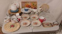 Full assortment of bowls, mugs, teapots, saucers, plates and trays displayed on a table