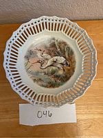 Top view of antique porcelain bowl showing octagonal pierced rim and detailed crane scene in center