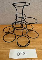 Front view of black metal cupcake or fruit display stand on wooden surface.