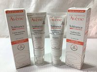 Two unopened tubes of Avene Tolerance Control Soothing Skin Recovery Cream and their boxes placed standing side by side on a fabric surface