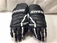 Pair of black Sherwood hockey gloves front view showing Sherwood text split on each glove and T90 Pro label on the fingers.
