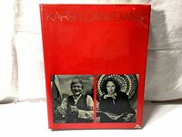 Front cover of the red hardcover photo book with silver embossed title 'KARSH CANADIANS' and two black and white portraits on the cover.