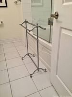 Front view showing two-tier chrome towel rack positioned next to bathtub