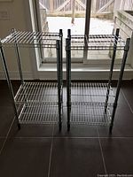 Front view of two wire storage racks side by side showing three shelves each with adjustable heights.