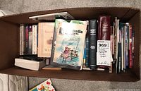 Top view photo of a box filled with various religious themed books.
