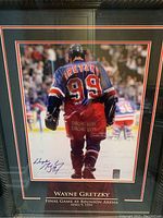 Full front view of framed autographed photo showing Gretzky walking on ice.