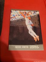 Front of the 1991 Fleer Ultra Ozzie Smith baseball card showing a photo of Ozzie Smith leaping for a catch in Cardinals uniform on a baseball field.