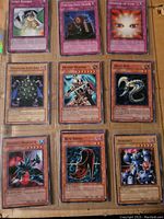 Photo of 10 Yu-Gi-Oh! cards in a binder page laid out in three rows, each card clearly visible with titles and artwork.