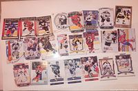 Top-down photo of 23 hockey cards spread out showing a mix of player images from different teams, eras, and uniform colors.