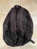 Back showing padded shoulder straps and overall polka dot design of the backpack.