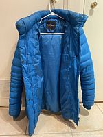 Front view of royal blue insulated women's winter coat with hood hanging open showing interior lining and label Angel Kiss.