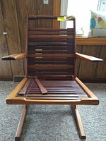 Front view of the wooden slat chair showing the detached slats on the seat and horizontal slats on the backrest.